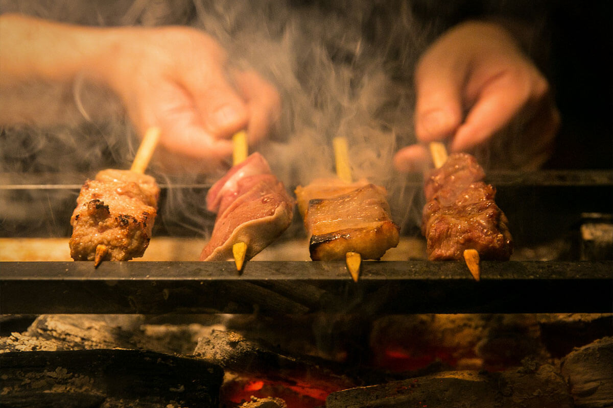 煙をあげて焼かれている焼き鳥